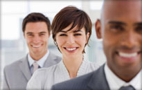 Three business people stood in a line smiling